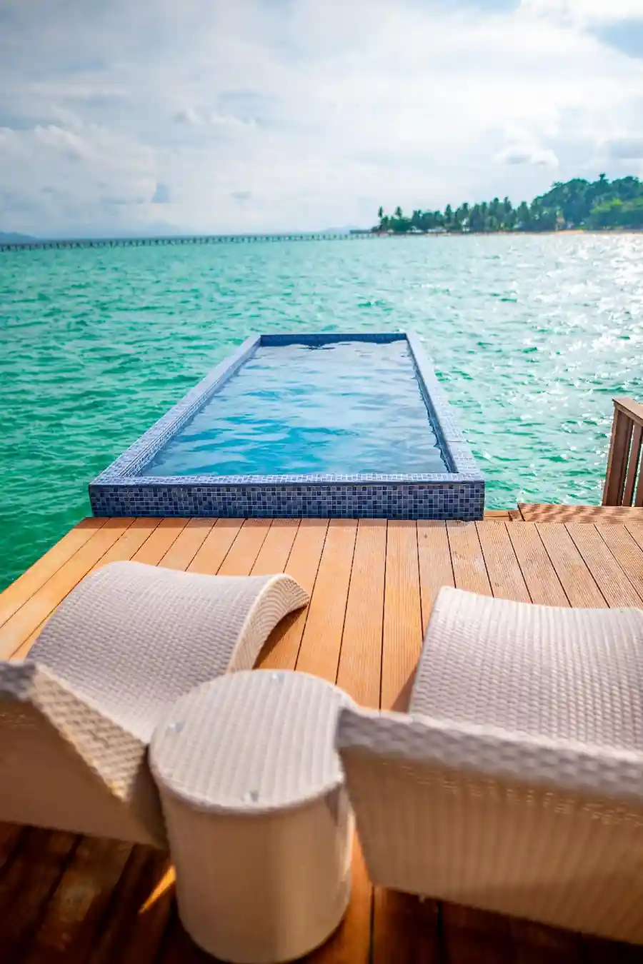 Private infinity plunge pool and sun deck with woven loungers overlooking the beautiful turquoise ocean at the Bedroom Deluxe Two Queen Beds, Turtle Seaweed Resort.
